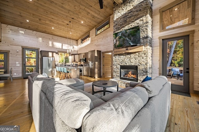 living room featuring hardwood / wood-style flooring, high vaulted ceiling, a wealth of natural light, and wood ceiling