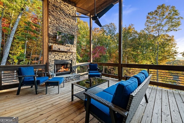 wooden deck with an outdoor living space with a fireplace