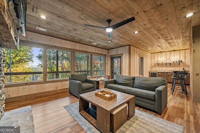 living room featuring a wealth of natural light, wooden walls, and wooden ceiling