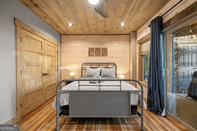 bedroom featuring wooden walls, wood ceiling, and wood-type flooring