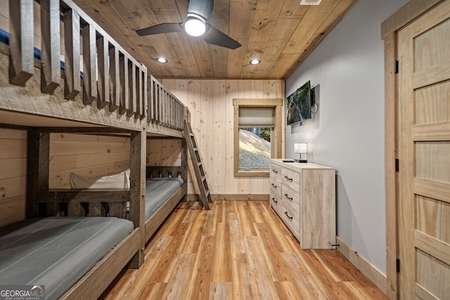 bedroom with wood walls, ceiling fan, light hardwood / wood-style floors, and wooden ceiling