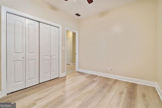 unfurnished bedroom featuring a closet, light hardwood / wood-style floors, and ceiling fan