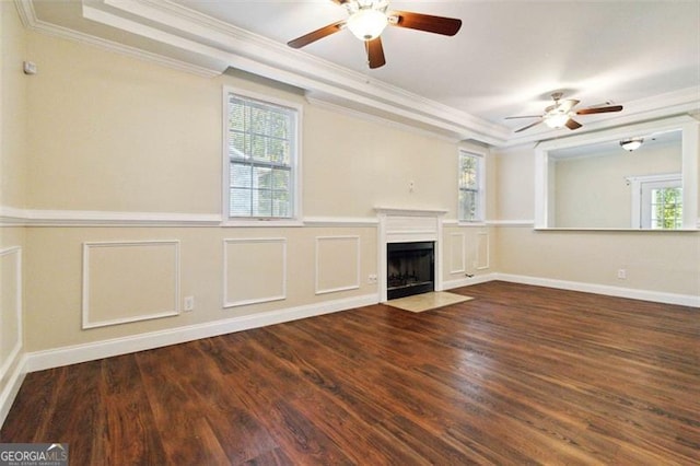 unfurnished living room featuring ornamental molding, dark wood-type flooring, and a wealth of natural light