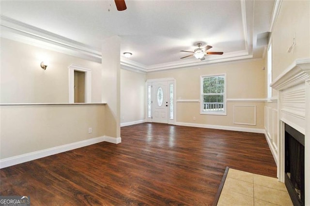 unfurnished living room with ornamental molding, ceiling fan, and dark hardwood / wood-style flooring