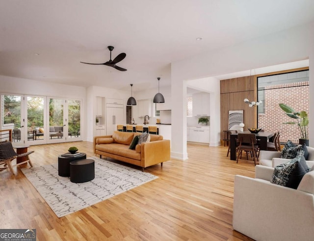 living room featuring ceiling fan and light hardwood / wood-style flooring