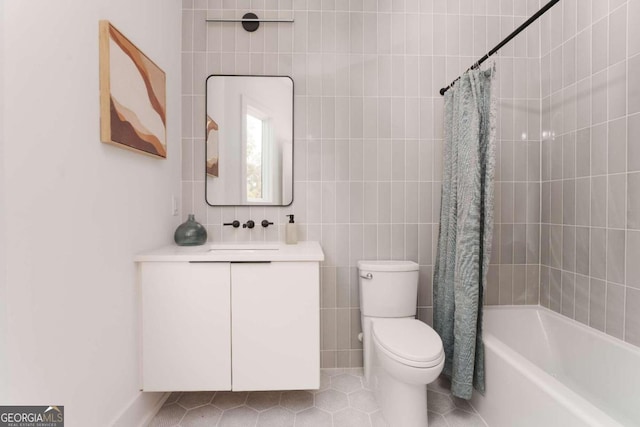 full bathroom featuring tile walls, vanity, shower / tub combo, tile patterned flooring, and toilet