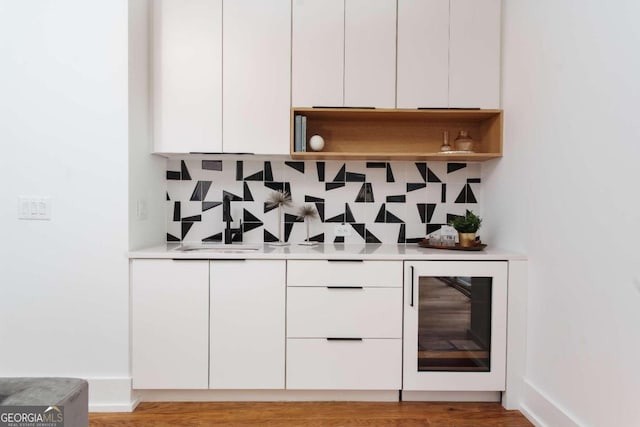 bar featuring white cabinetry and backsplash