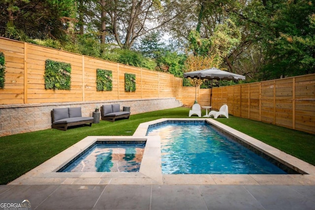 view of swimming pool featuring a patio area, outdoor lounge area, a yard, and a jacuzzi