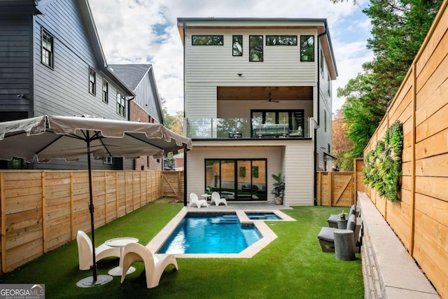 back of house featuring a lawn, a patio, and a fenced in pool