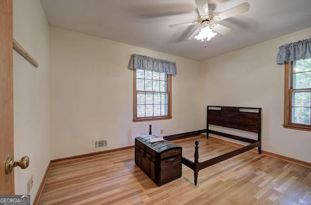 bedroom featuring light wood finished floors, visible vents, and baseboards