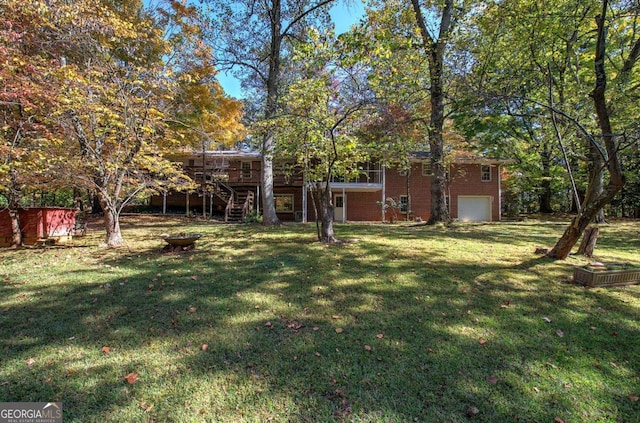 view of yard with stairs, a deck, and a garage