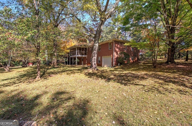 view of yard with a garage and a sunroom