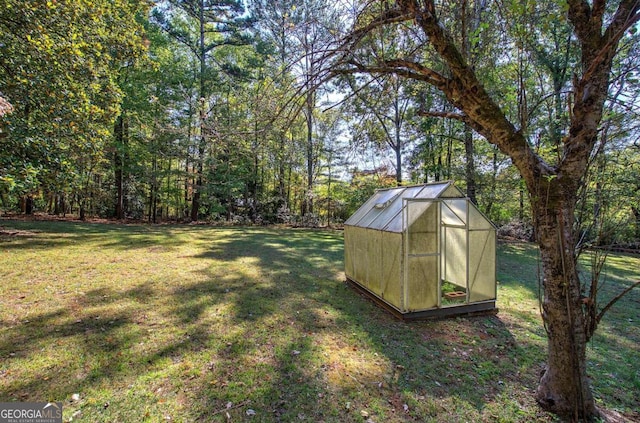 view of yard featuring an outbuilding and a greenhouse