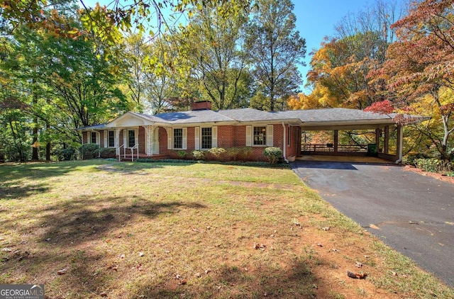 ranch-style home featuring a chimney, aphalt driveway, an attached carport, a front lawn, and brick siding