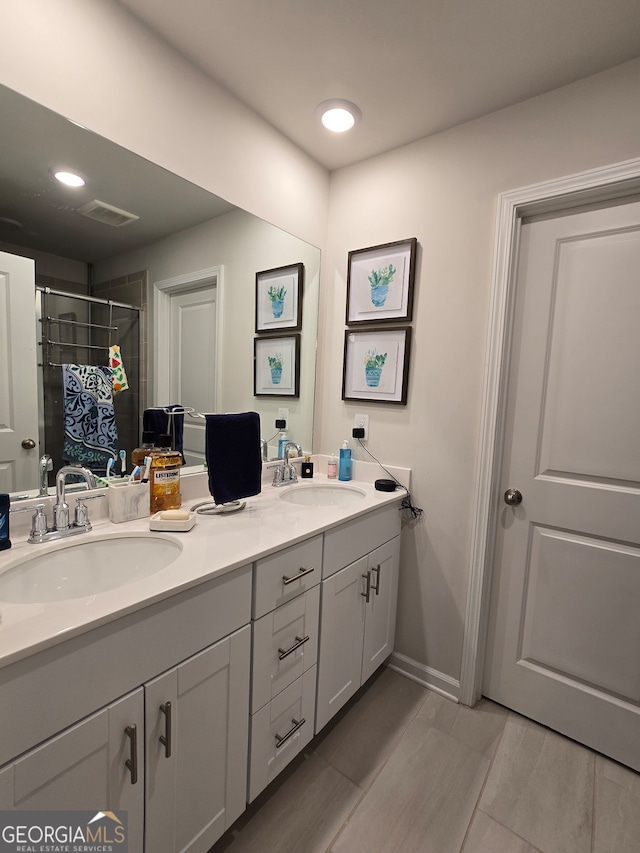 bathroom featuring a shower with shower door and vanity