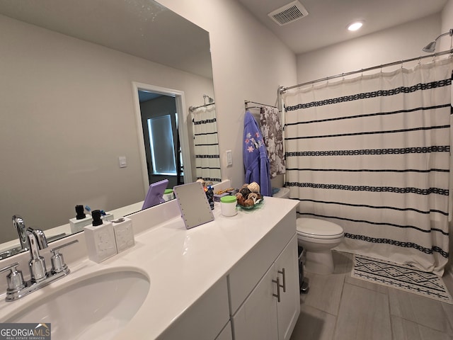 bathroom featuring vanity, tile patterned flooring, and toilet