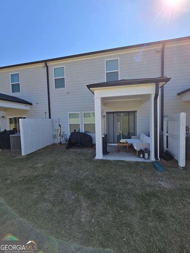 rear view of property featuring a lawn, a patio, and an outdoor hangout area