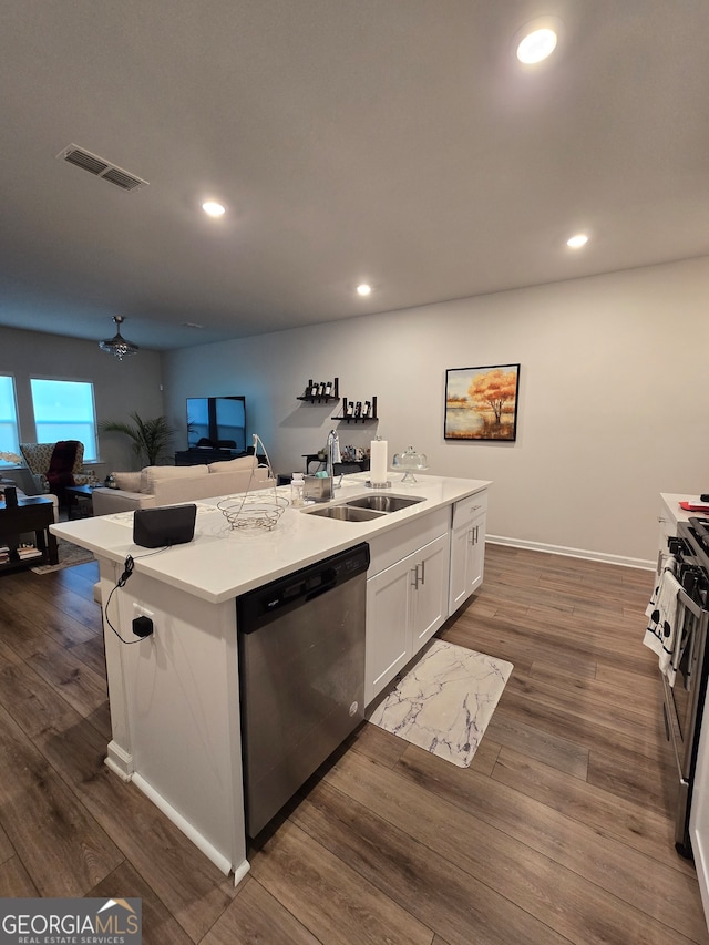 kitchen with stainless steel appliances, dark hardwood / wood-style floors, sink, an island with sink, and white cabinets