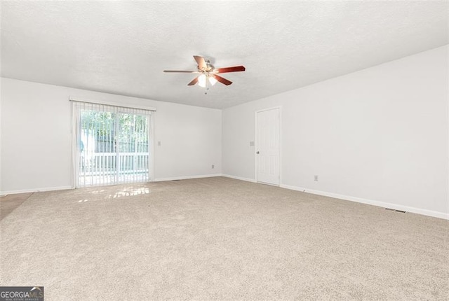 carpeted spare room featuring a textured ceiling and ceiling fan