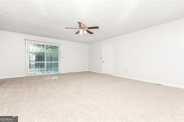 carpeted spare room featuring a textured ceiling and ceiling fan