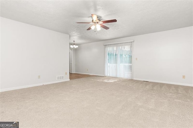 carpeted empty room with a textured ceiling and ceiling fan with notable chandelier