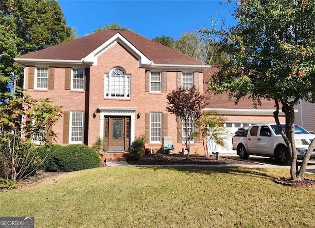 colonial home featuring a garage and a front yard