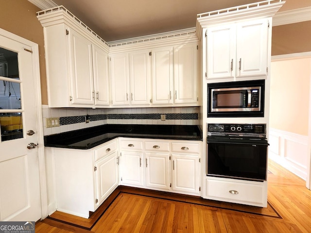 kitchen featuring oven, crown molding, backsplash, white cabinets, and stainless steel microwave