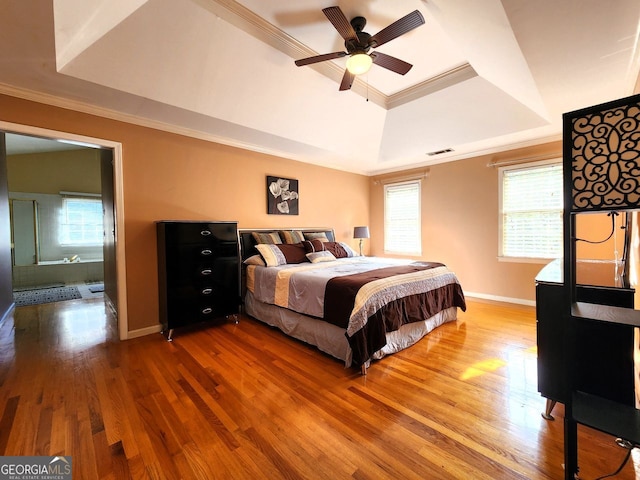 bedroom featuring hardwood / wood-style flooring, ceiling fan, a raised ceiling, and ornamental molding