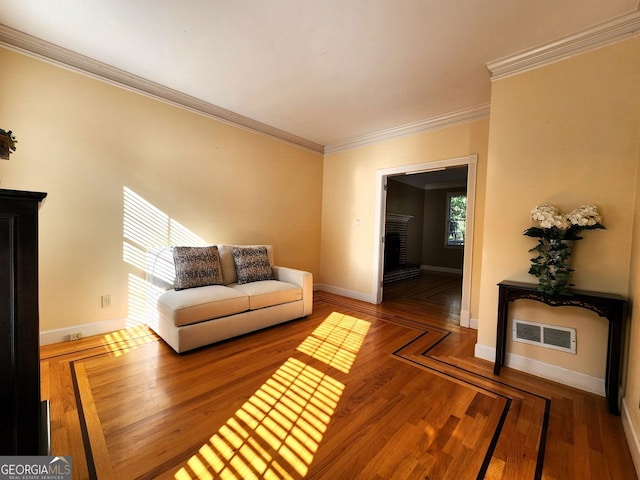 living room featuring ornamental molding, a brick fireplace, and wood-type flooring