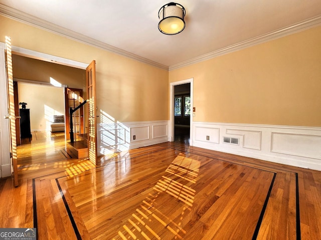 spare room featuring hardwood / wood-style floors and ornamental molding