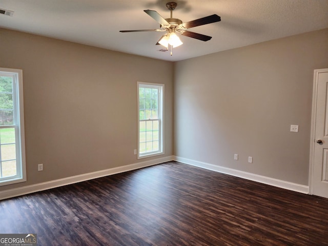 spare room with ceiling fan, a textured ceiling, a wealth of natural light, and dark hardwood / wood-style flooring