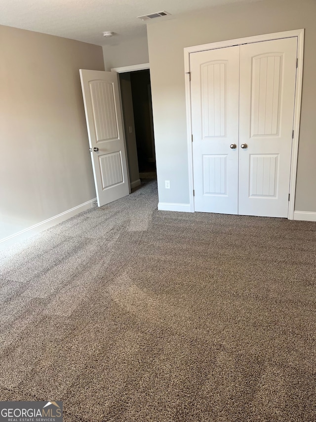 unfurnished bedroom with carpet and a closet