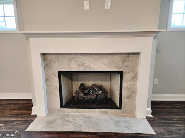 interior details with hardwood / wood-style floors and a tiled fireplace