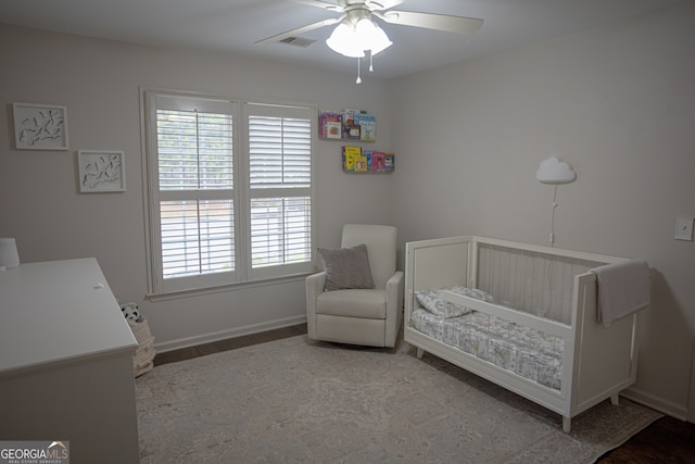 bedroom with a nursery area and ceiling fan