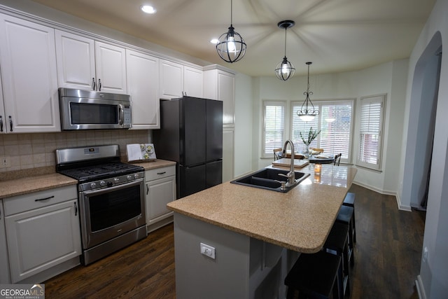 kitchen with a kitchen island with sink, sink, white cabinets, and appliances with stainless steel finishes