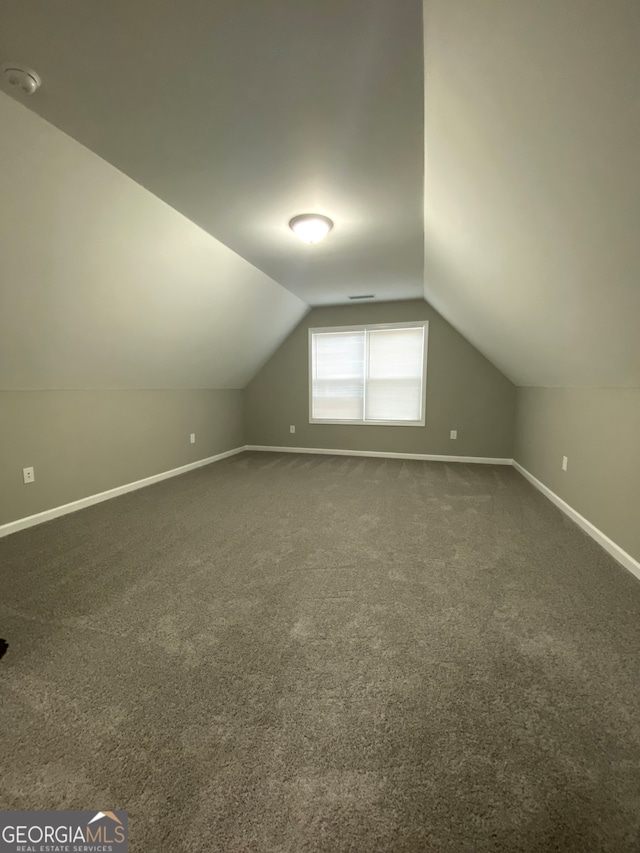 bonus room featuring lofted ceiling and carpet flooring