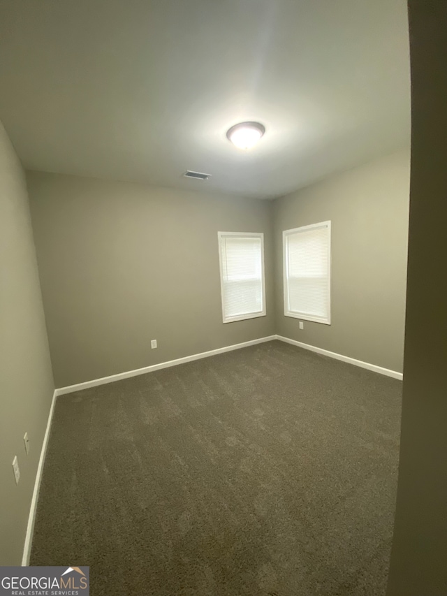 empty room featuring dark colored carpet