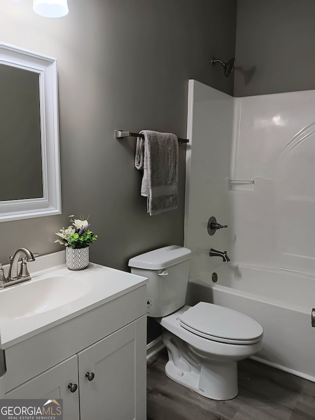 full bathroom with vanity, hardwood / wood-style floors, toilet, and shower / bathtub combination