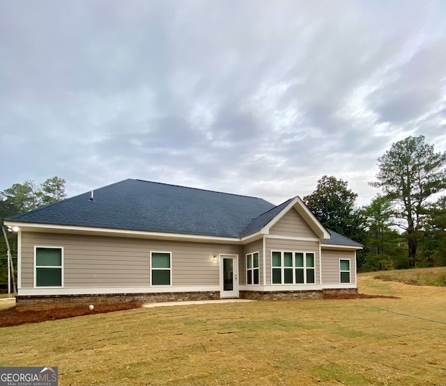 rear view of house featuring a lawn