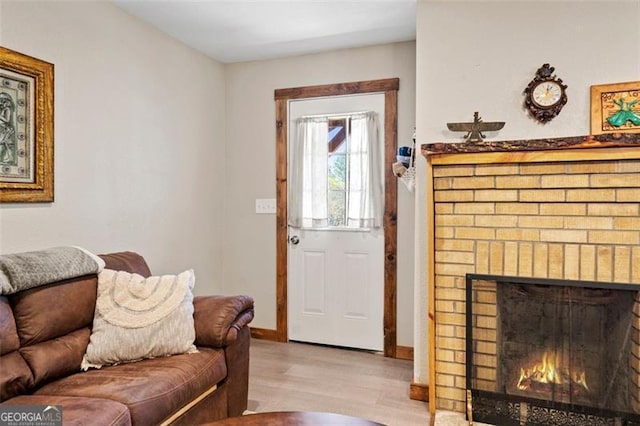 living room with light hardwood / wood-style floors and a brick fireplace