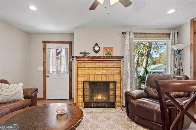 living room with ceiling fan and a brick fireplace