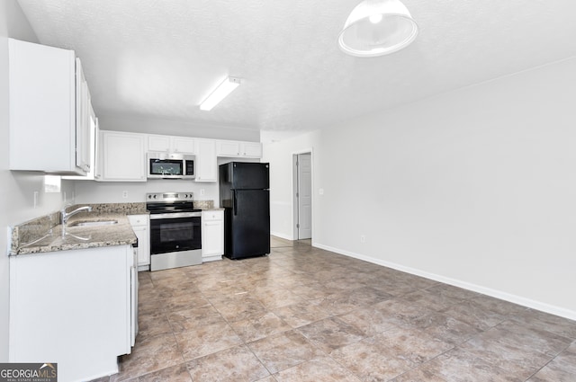 kitchen with light stone countertops, sink, a textured ceiling, stainless steel appliances, and white cabinets