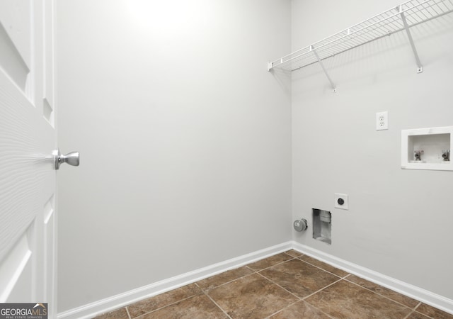 washroom with electric dryer hookup, washer hookup, and dark tile patterned flooring