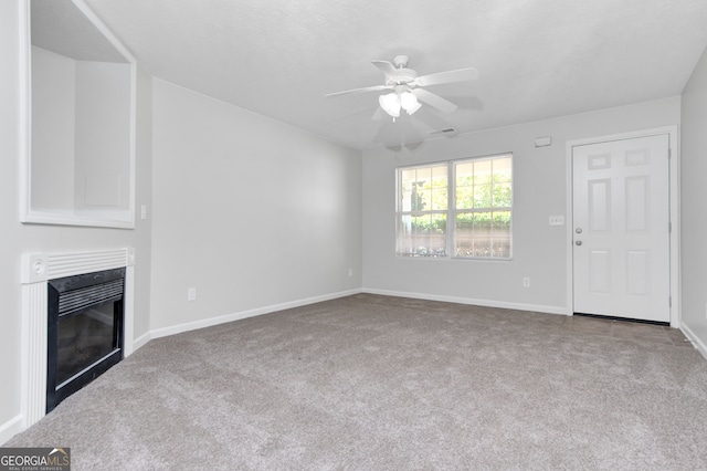 unfurnished living room with carpet and ceiling fan