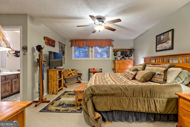 bedroom with connected bathroom, ceiling fan, light colored carpet, and a textured ceiling