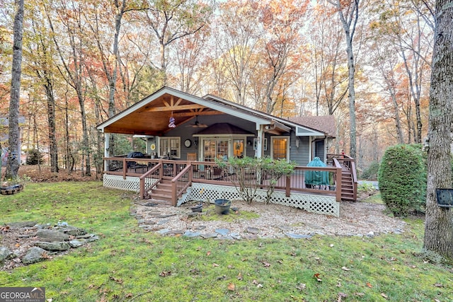 view of front of property with ceiling fan, a front lawn, and a wooden deck