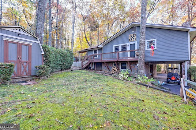 rear view of property featuring a deck, a storage unit, and a lawn