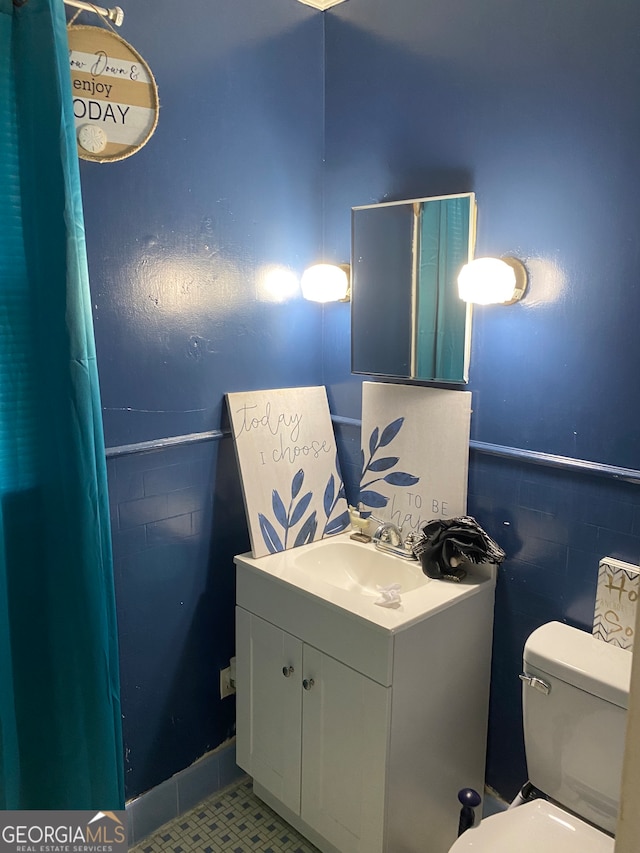 bathroom featuring vanity, toilet, and walk in shower