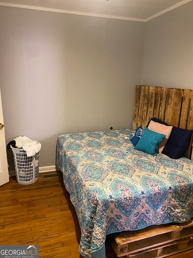 bedroom featuring ornamental molding and hardwood / wood-style flooring