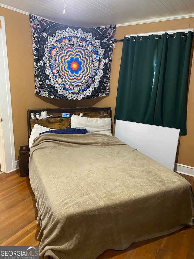 bedroom with crown molding and hardwood / wood-style flooring